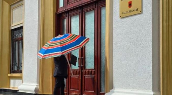 “Zbriti maloku në plazh”, Asllan Dogjani shkon në Kuvend me çadër: Do ta vendos tek…